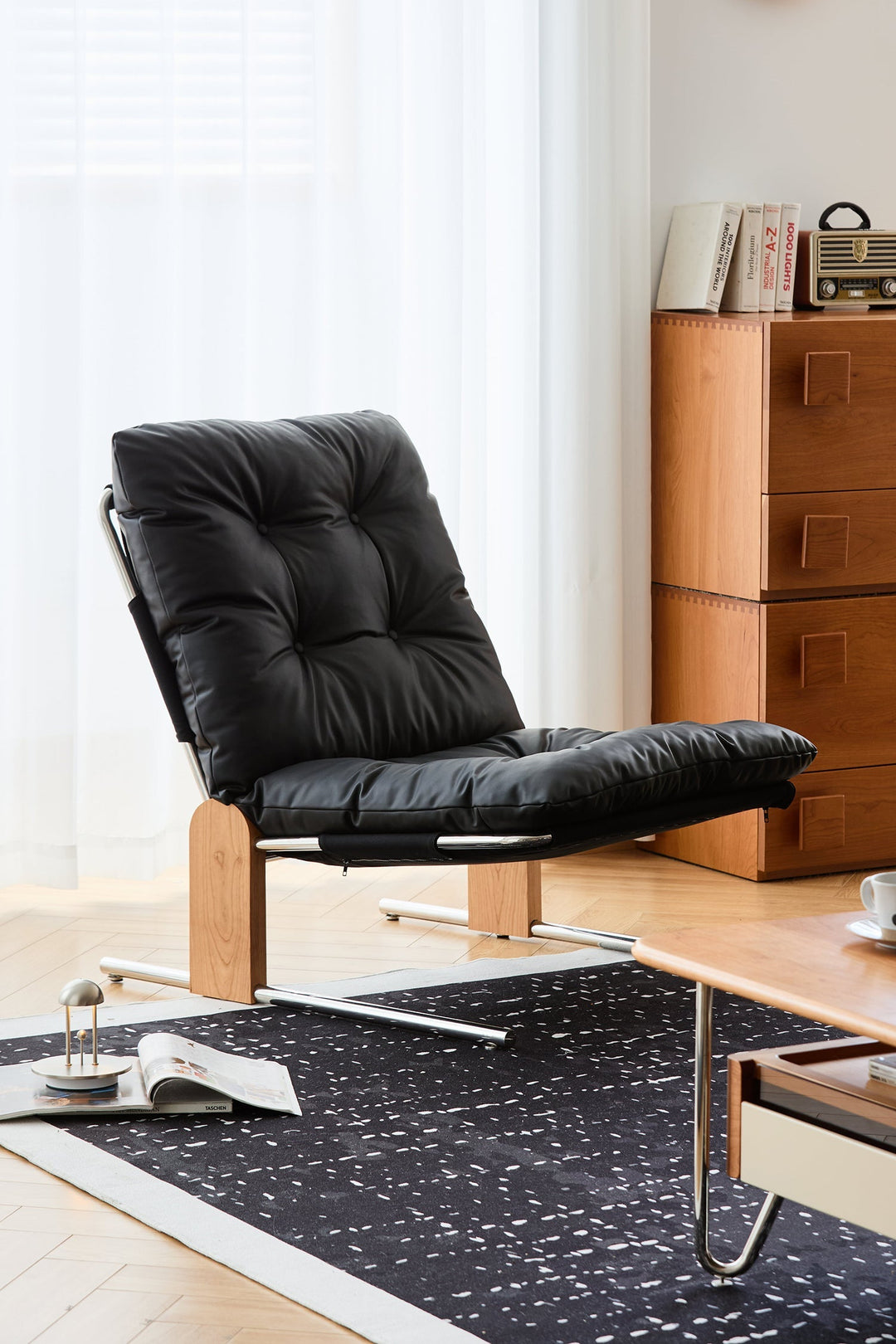 Black leather chair in a room with wooden furniture and a rug.