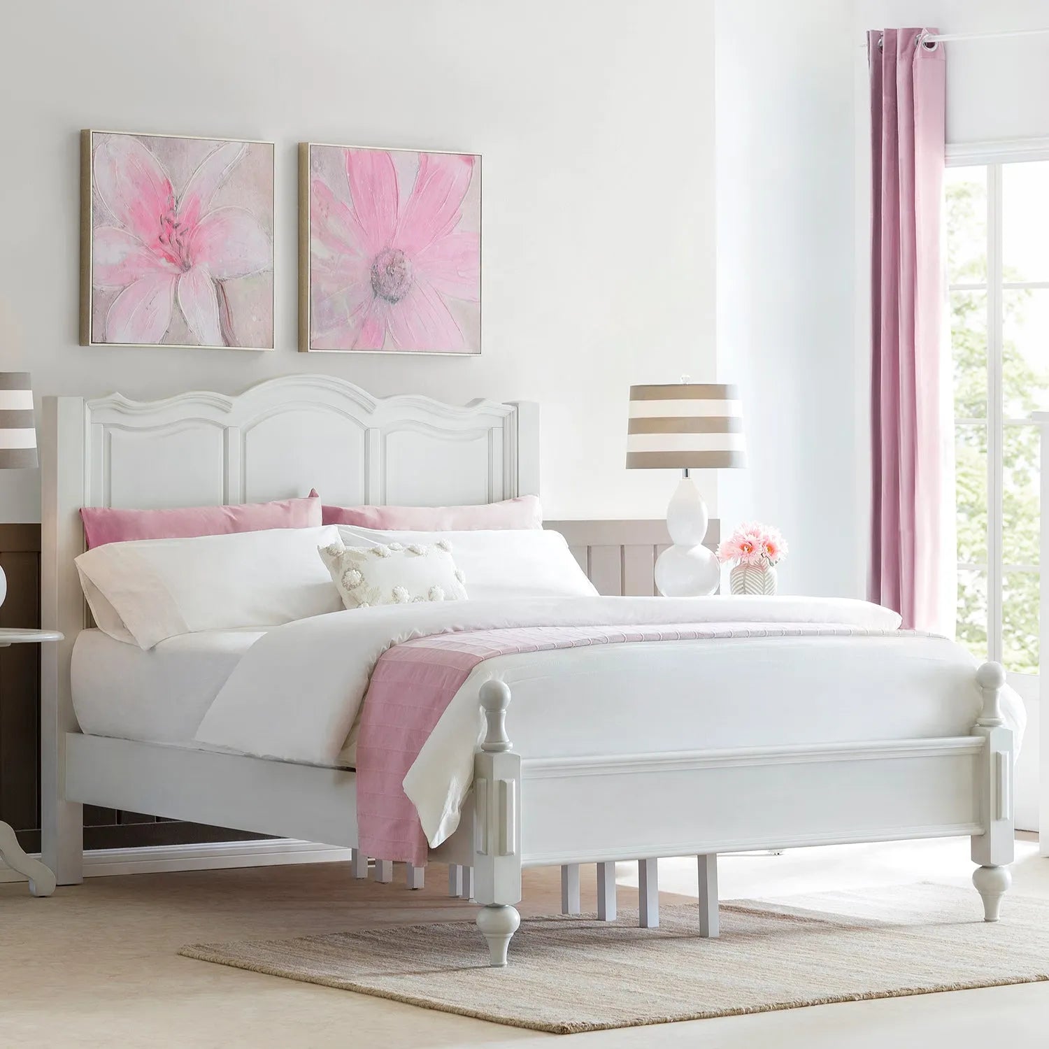 Charming white bed frame with elegant headboard and footboard, set in a bright bedroom with pastel pink accents, linking to Loft Home's bed frames by type collection.