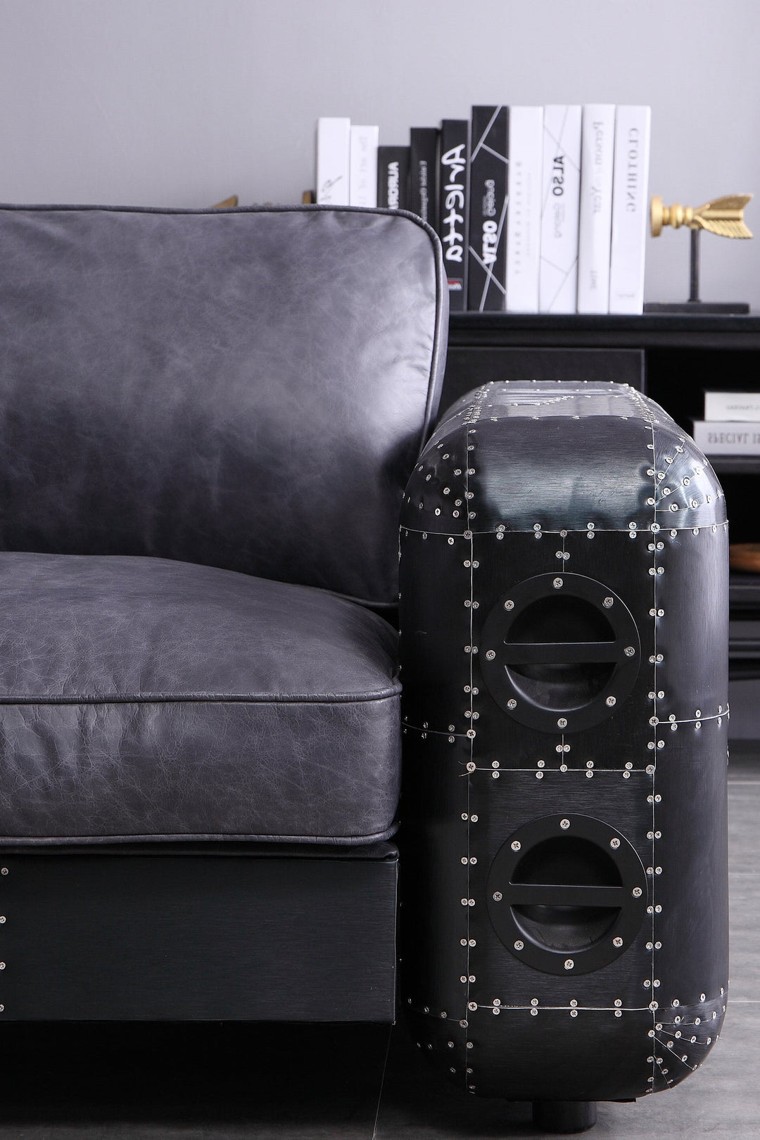 Black metal sofa in a living room setting, featuring a metal armrest and genuine leather seat and cushion. Loft Home Singapore metal sofas featured product.