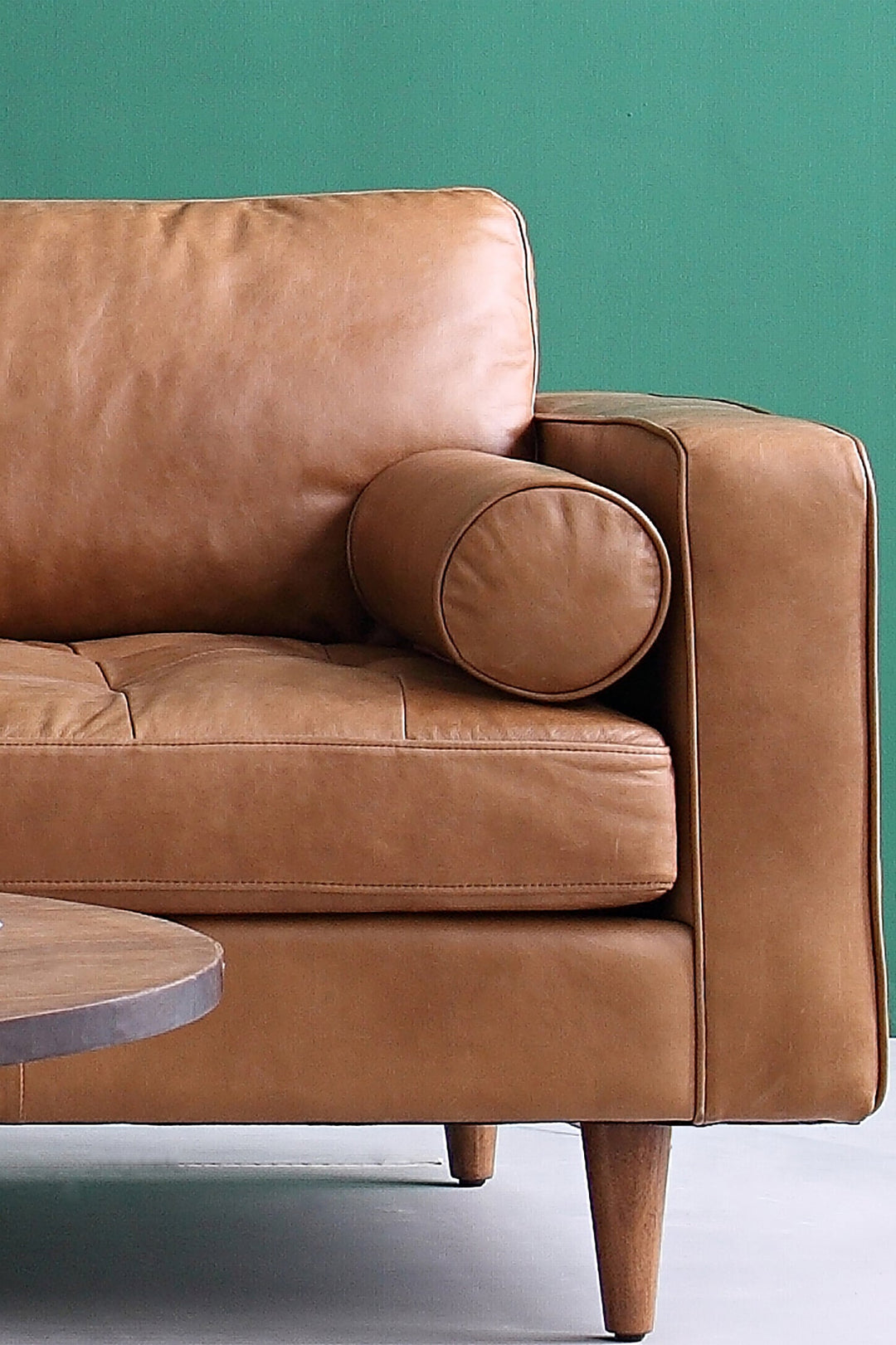 Brown leather sofa against a green wall. Loft Home genuine leather sofas collection collection photo.