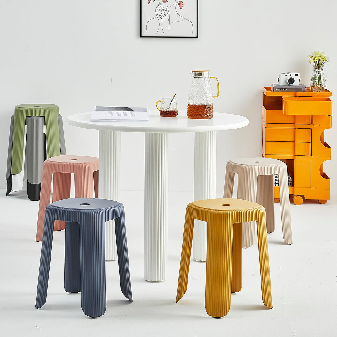 Modern plastic stools in vibrant colors, featuring ribbed textures and stackable design, ideal for versatile seating in indoor or outdoor spaces.