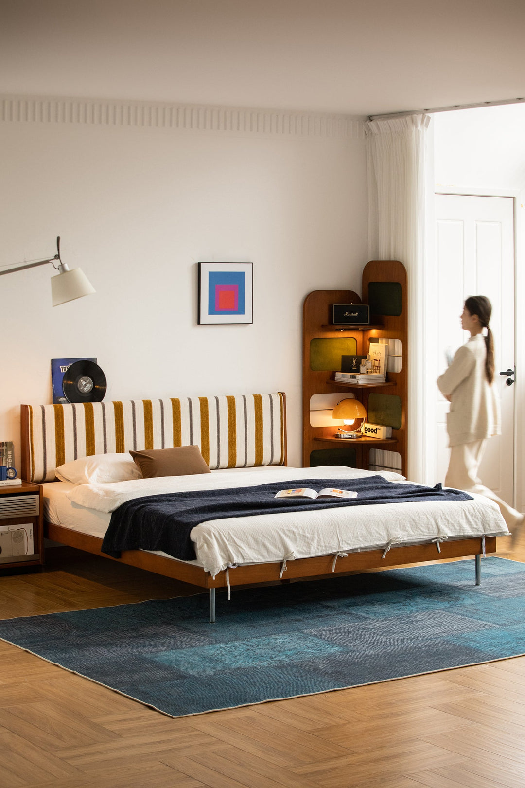 Modern wooden bed with striped upholstered headboard, styled in a warm contemporary bedroom, offering restful comfort for Singapore homes.