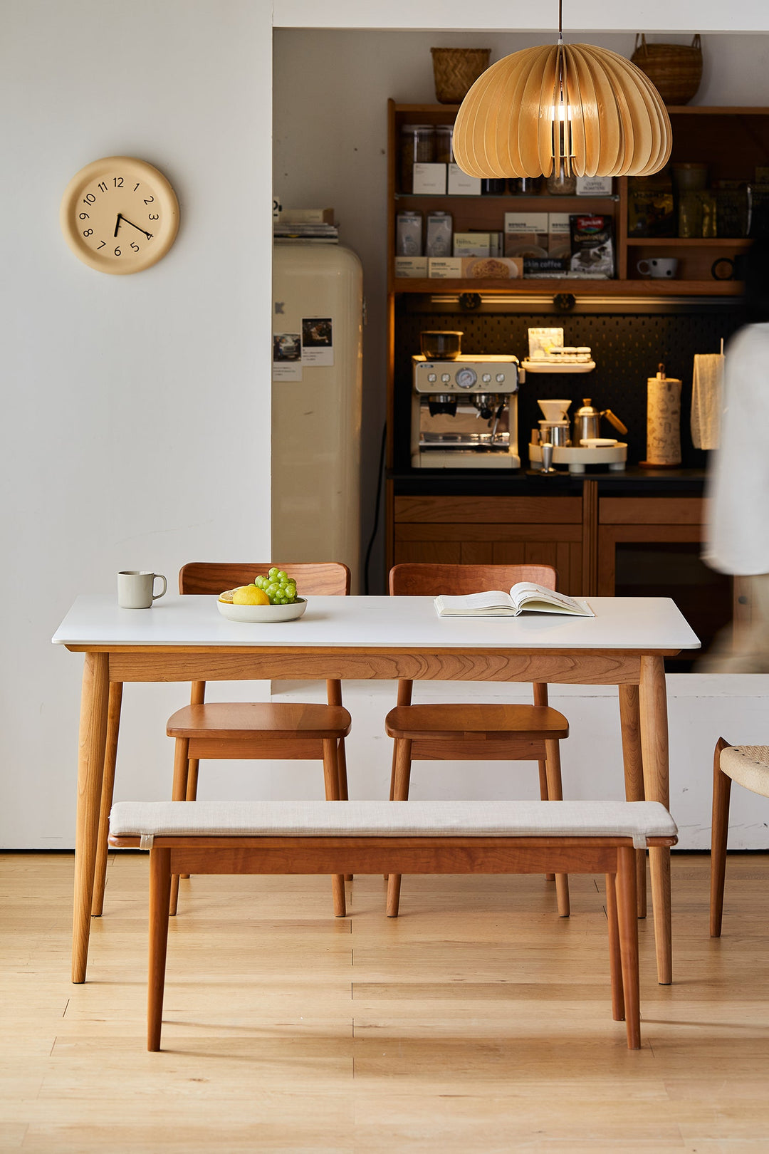 Scandinavian-style dining table set with light wood finish and white tabletop, paired with matching chairs and bench, styled for a cozy minimalist kitchen café corner.