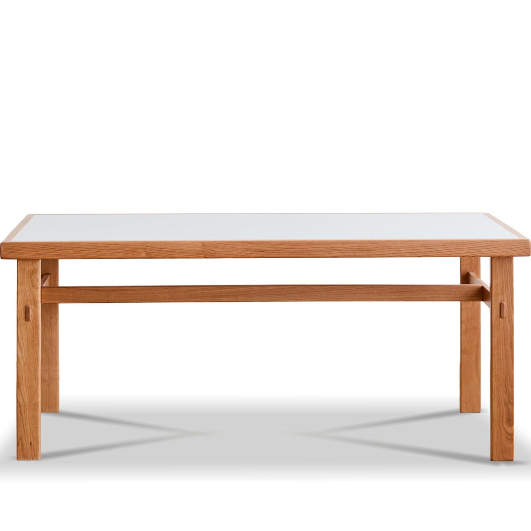 Wooden dining table with a glass top on a white background