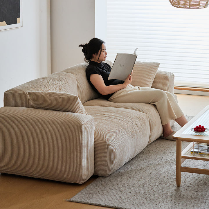 Cream corduroy velvet fabric 4 seater sofa square in panoramic view.