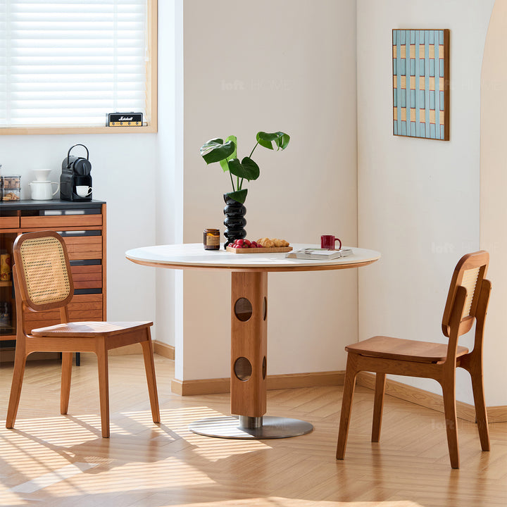Scandinavian cherry wood sintered stone round dining table timeless in still life.