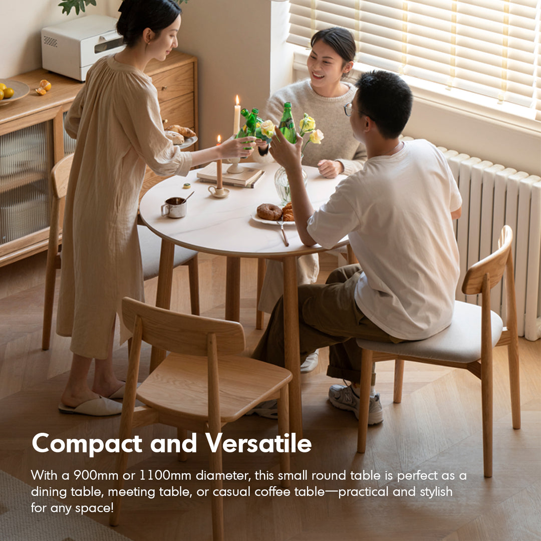 Scandinavian oak wood sintered stone round dining table orb with context.