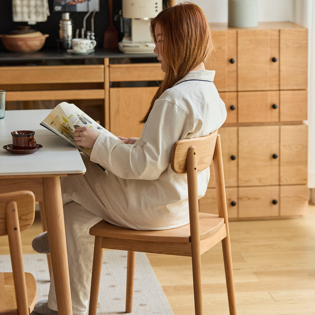 Scandinavian cherry wood dining chair green in real life style.