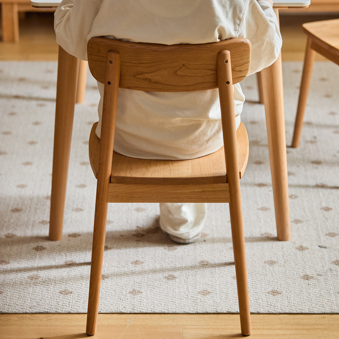 Scandinavian cherry wood dining chair green with context.