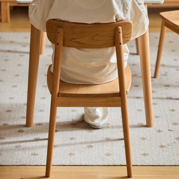 Scandinavian cherry wood dining chair green with context.