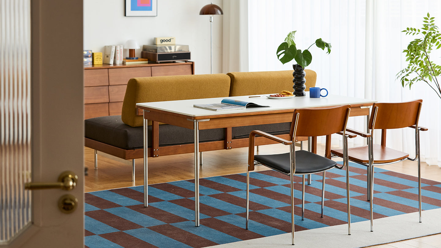 Modern dining table with wooden chairs styled in a warm contemporary living space, highlighting curated furniture selections for Singapore homes.