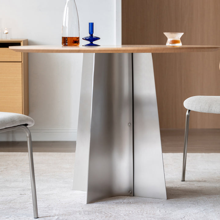 Minimalist ash wood veneer stainless steel round dining table aeri in panoramic view.
