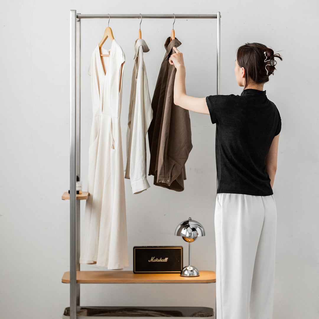Minimalist stainless steel clothes hanger hera with context.