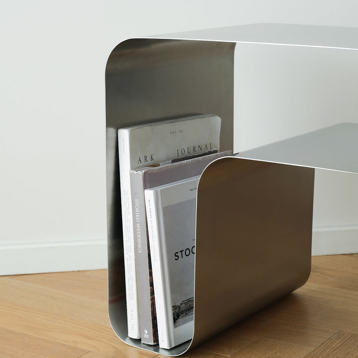 Minimalist steel side table arc in close up details.