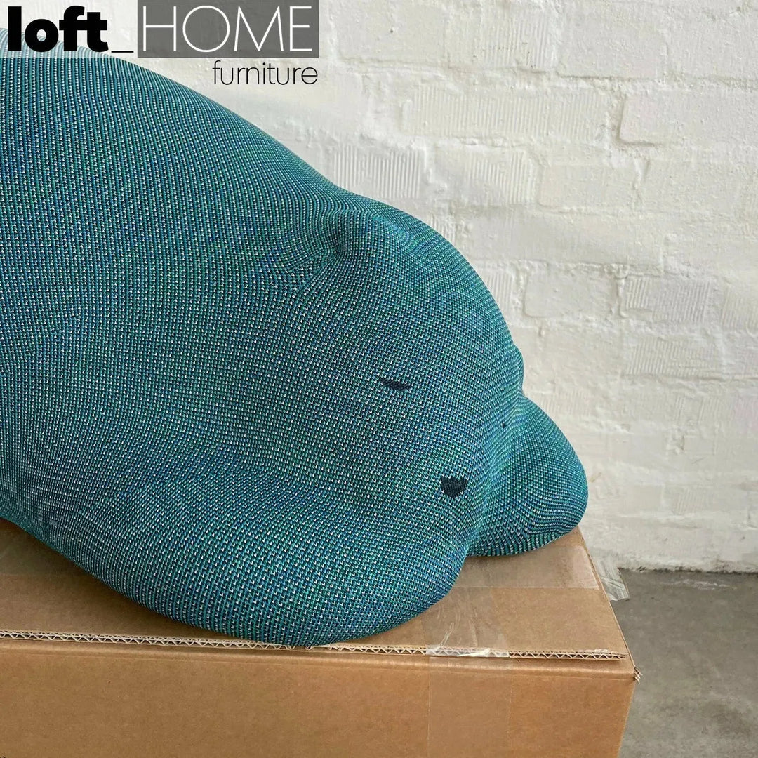 Contemporary knit fabric ottoman resting bear in still life.