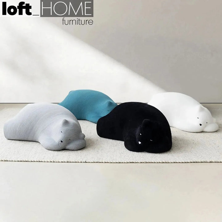 Contemporary velvet ottoman resting bear black with context.