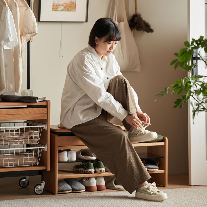 Scandinavian cherry wood shoe changing bench mori in panoramic view.
