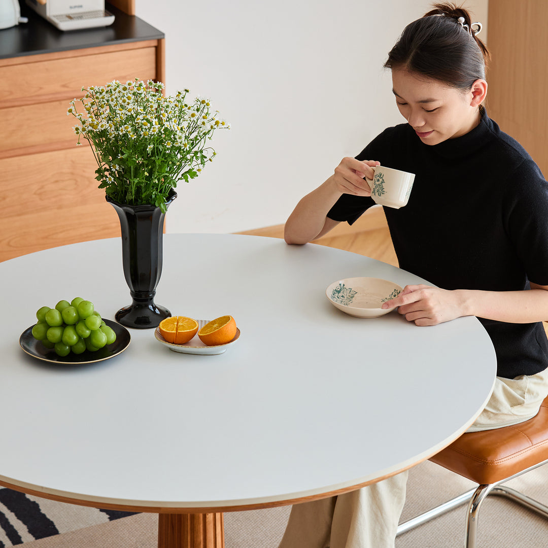 Scandinavian cherry wood sintered stone round dining table grey in real life style.