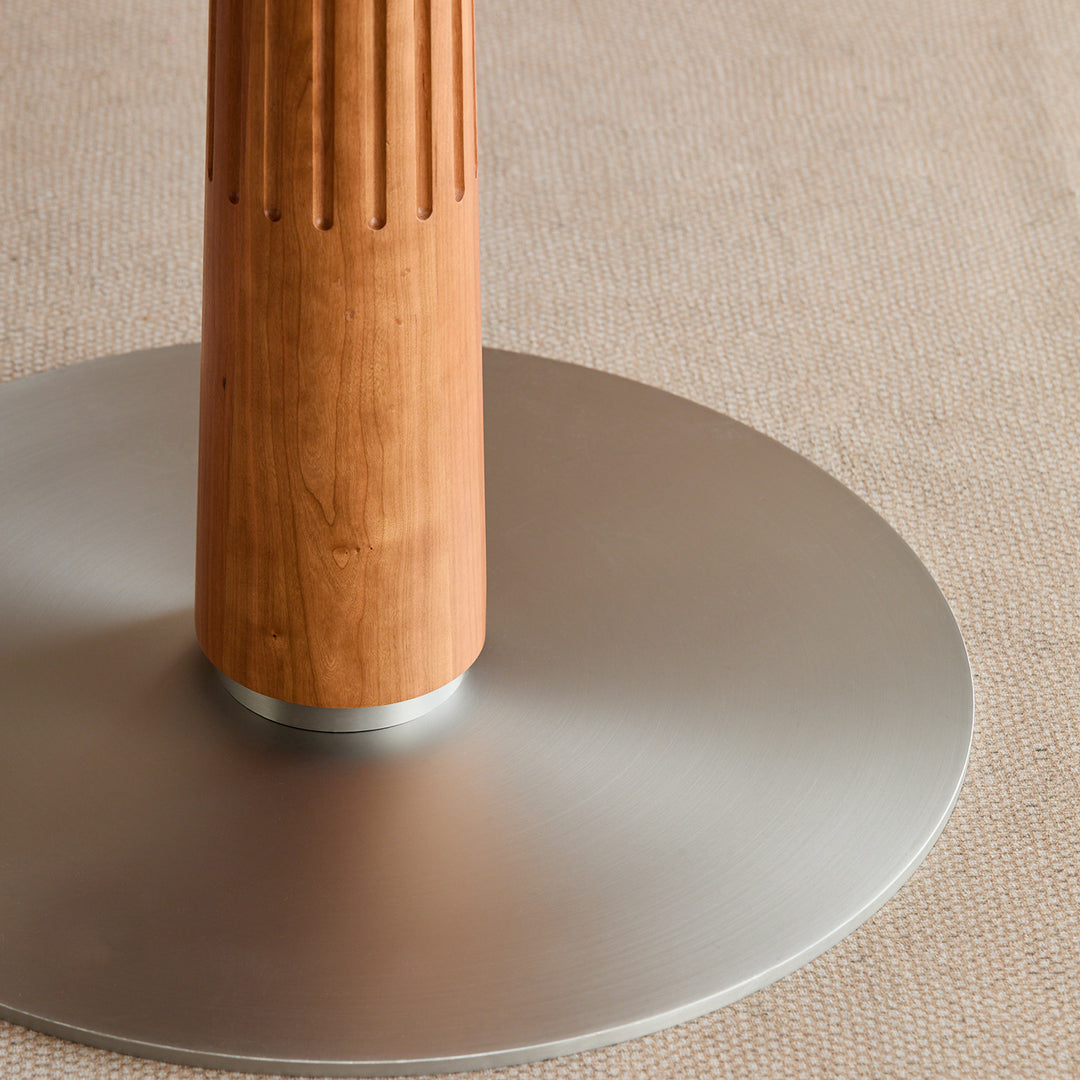 Scandinavian cherry wood sintered stone round dining table grey with context.