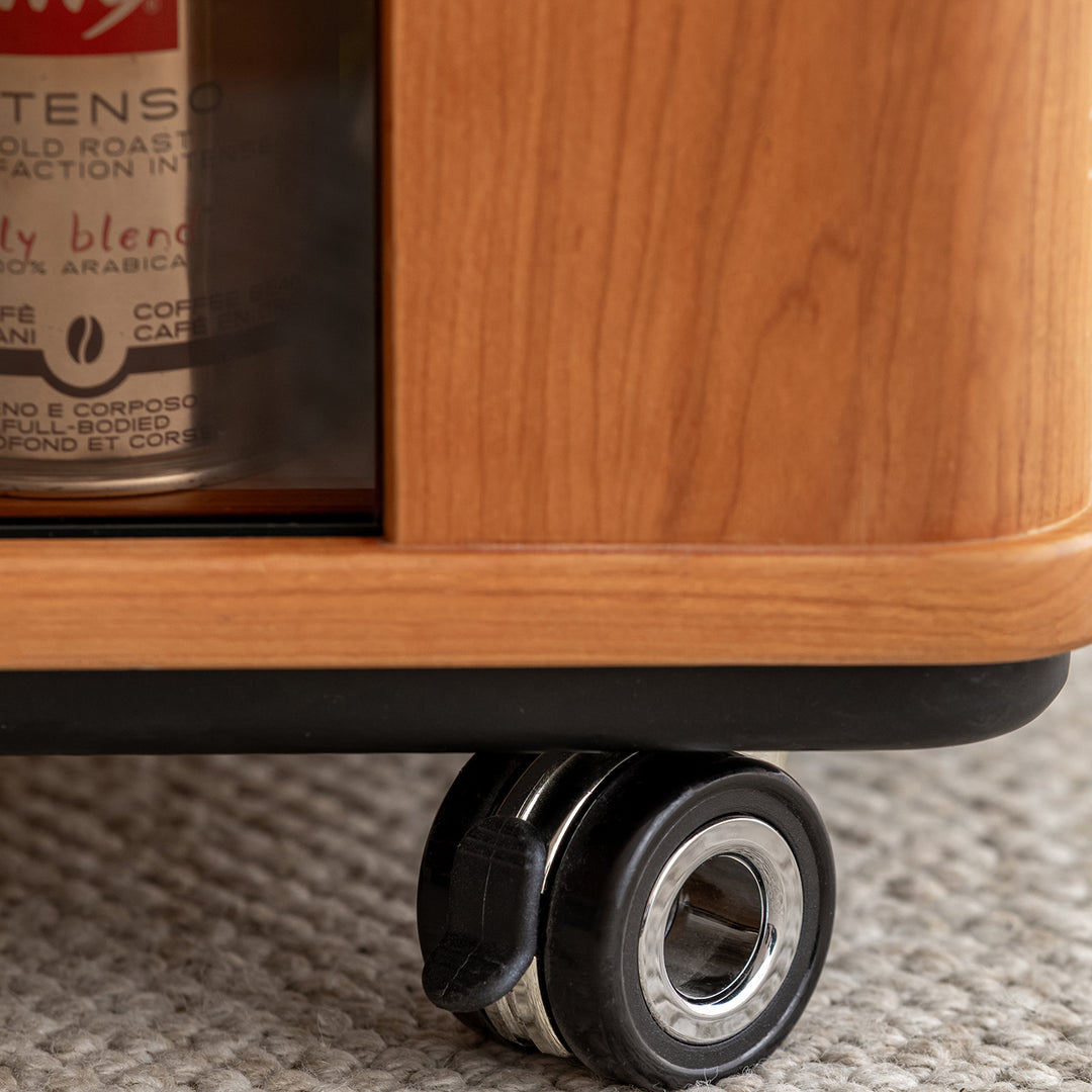 Scandinavian cherry wood wheeled trolley side table drift in still life.