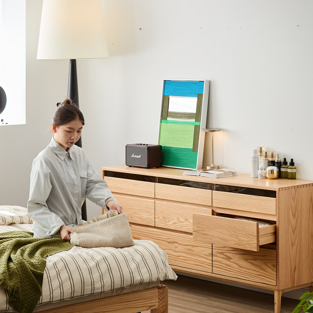 Scandinavian oak wood chest of 8 drawers floating light in still life.