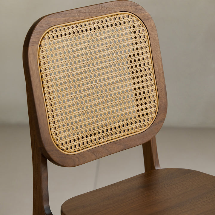 Vintage walnut wood rattan dining chair nook in still life.